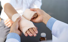 médico vendando la mano de un paciente