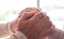manos de dos personas mayores entrelazadas